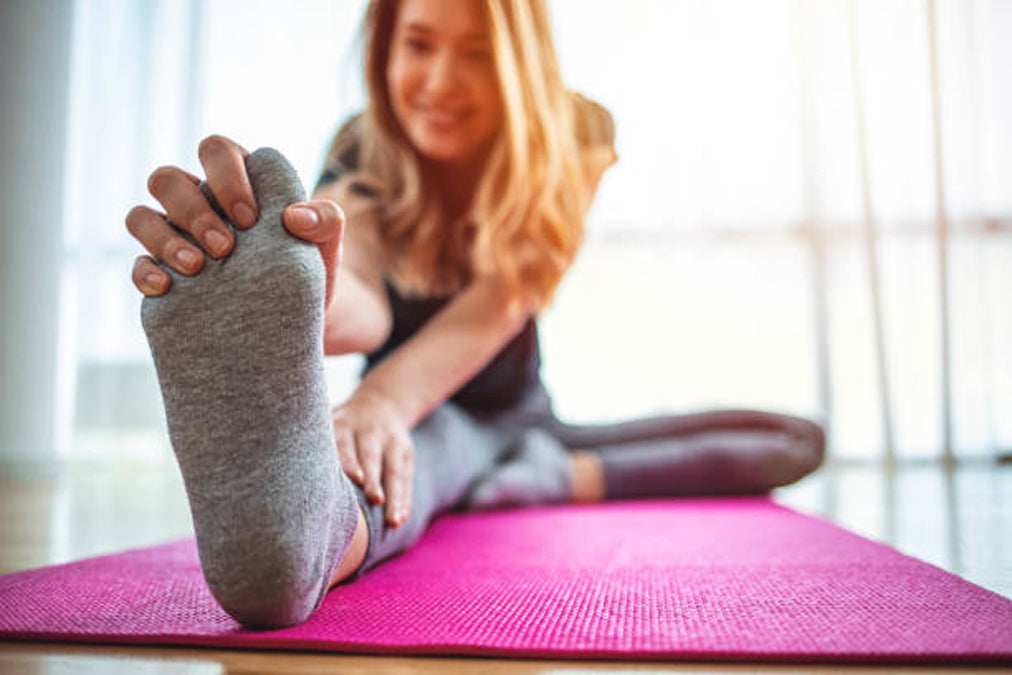 Person stretching on a pink mat with a blurred background